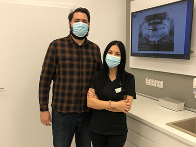 Medic stomatolog in dreapta, pacient in stanga in cabinetul de medicina dentara