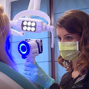 Medic care testează un pacient cu aparatul Velscope, ce depistează cancer oral