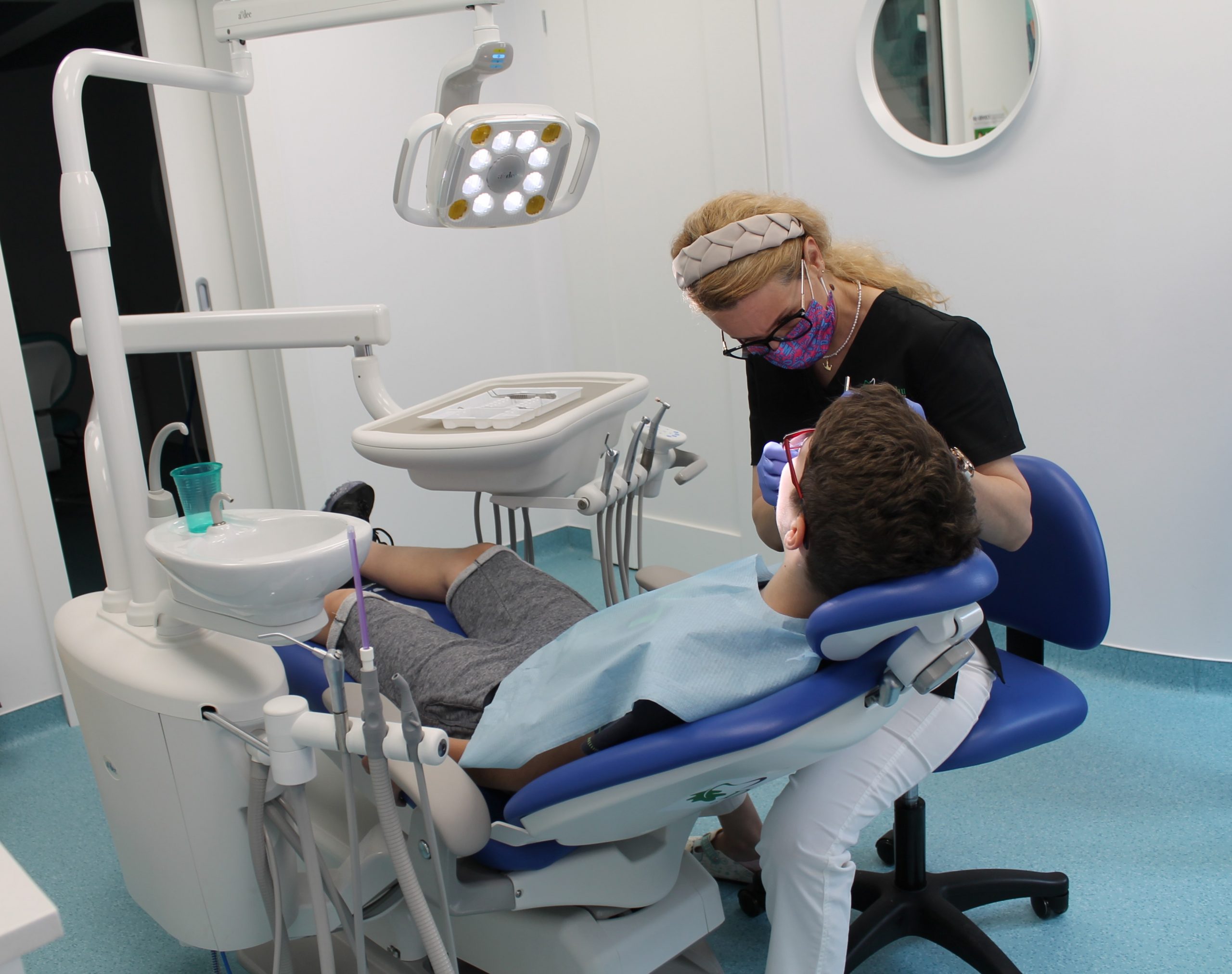 Dr. Mihaela Parlog pe scaunul stomatologic, in timpul unui tratament. 