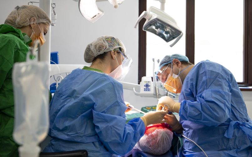 Dr. Ionut Leahu in dreapta in timpul interventie chirurgicale de refacere a danturi cu implanturi dentare