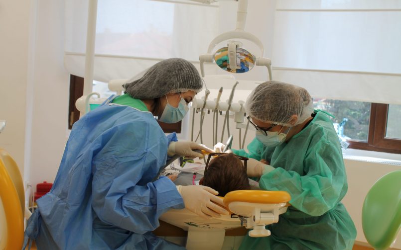 Inhalosedarea la copii folosita in timpul tratamentului stomatologic de catre medic in dreapta si asistenta in stanga