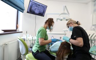 sensibilitate dentara la rece tratata in cabinetul de medicina dentara de catre medic in dreapta si asistenta medicala in stanga