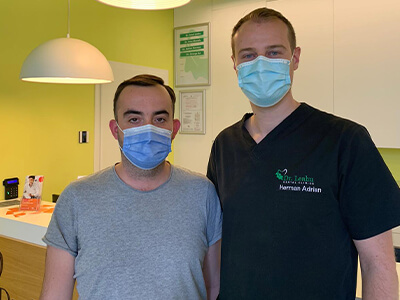 Medic stomatolog in dreapta, pacient in stanga in clinica dentara