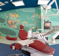 Scaun stomatologic intr-un cabinet pentru copii cu picturi ale personajelor din Academia Spatiala