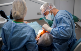 medic specialist chirurg intr-o interventie chirurgicala cu implant dentar