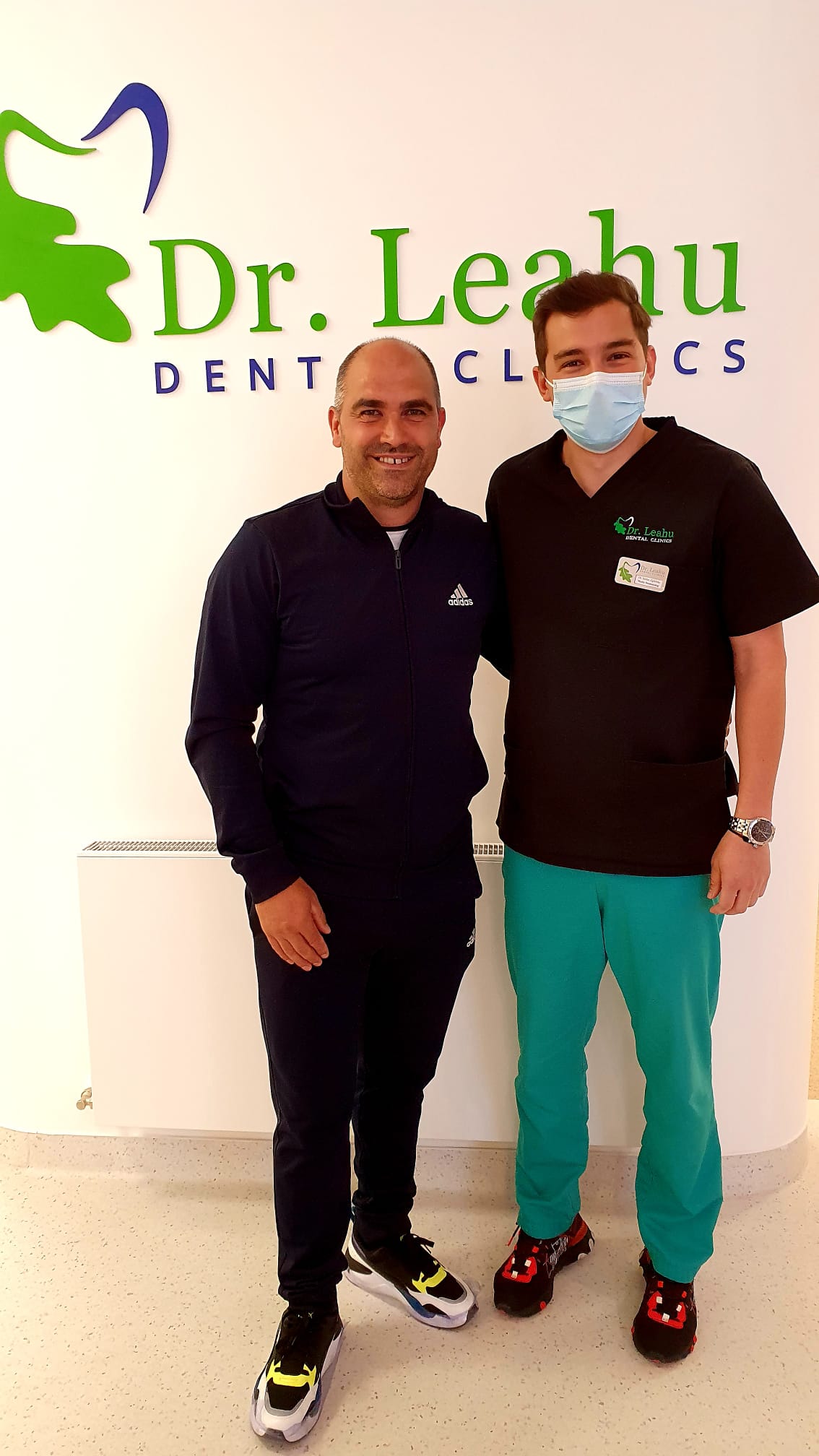 Medic stomatolog in dreapta, pacient in stanga in clinica dentara