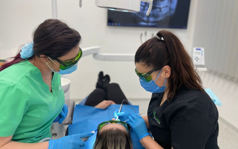 asistenta medicala asista la un tratament parodontal efectuat de medicul parodontolog